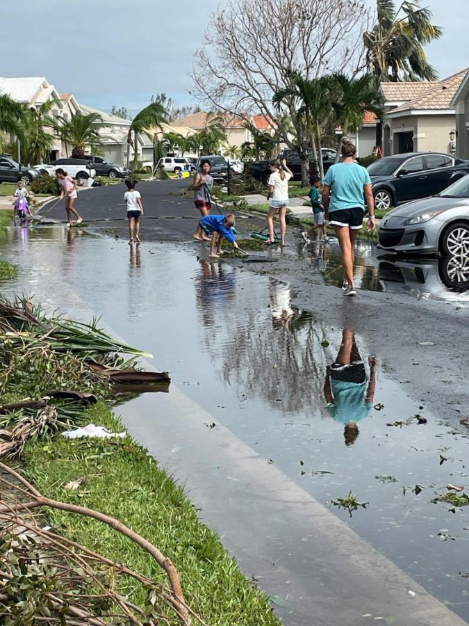 People in Cape Coral wade in the water left over by Hurricane Ian.